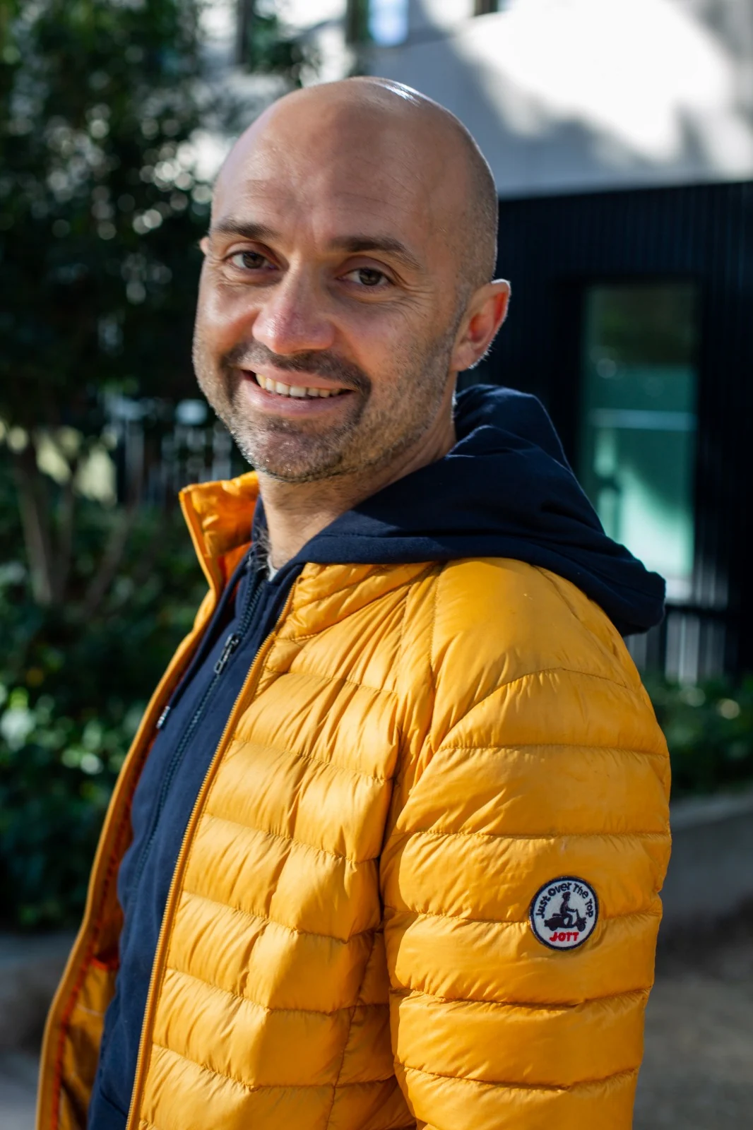 Christophe Jacques, veste jaune, sourit en plein air